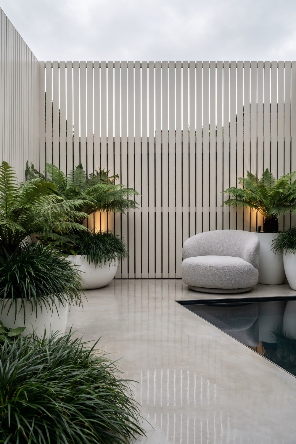 Boucle chair and reflecting pool on shady patio