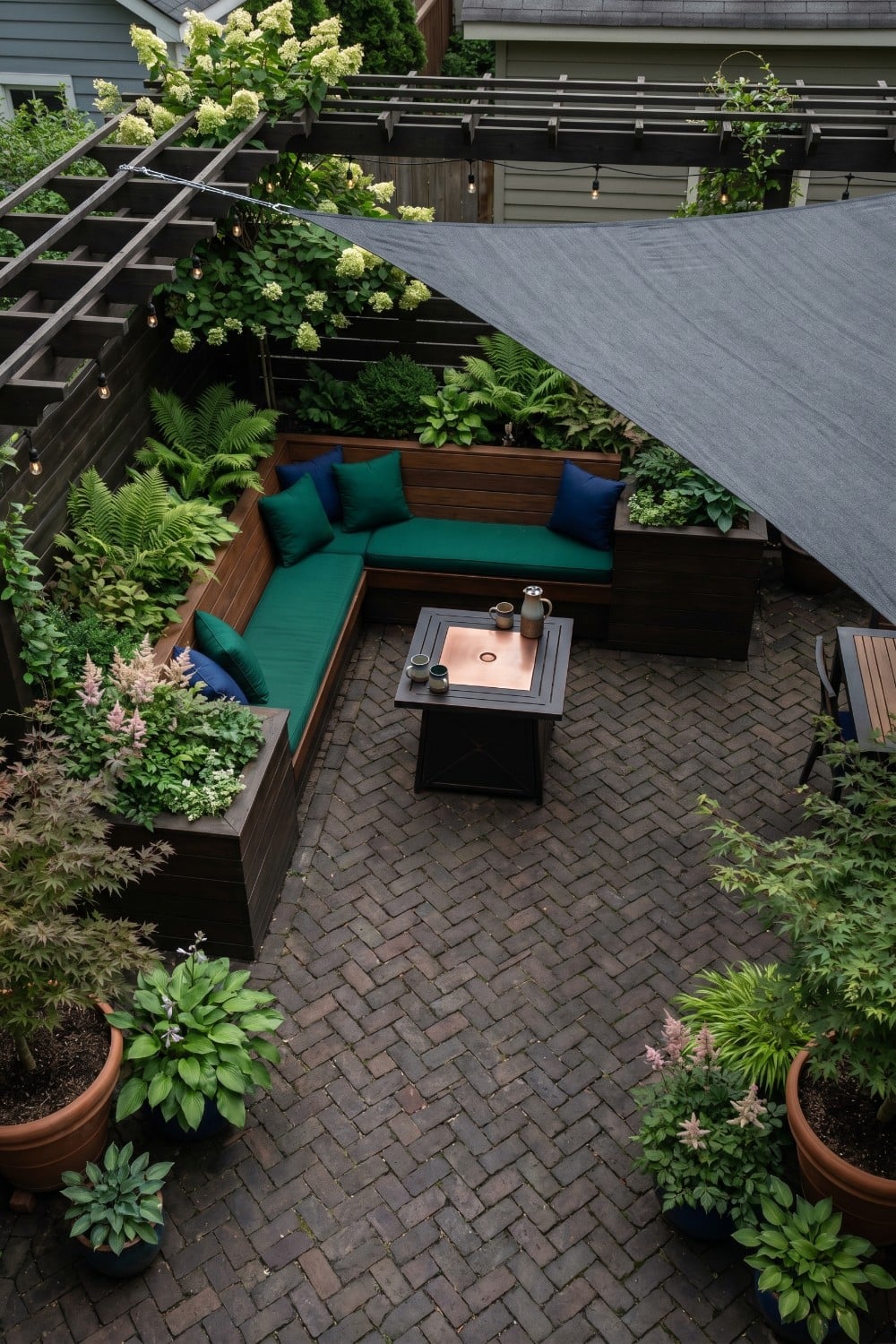 Shady patio with emerald cushions and sun sail