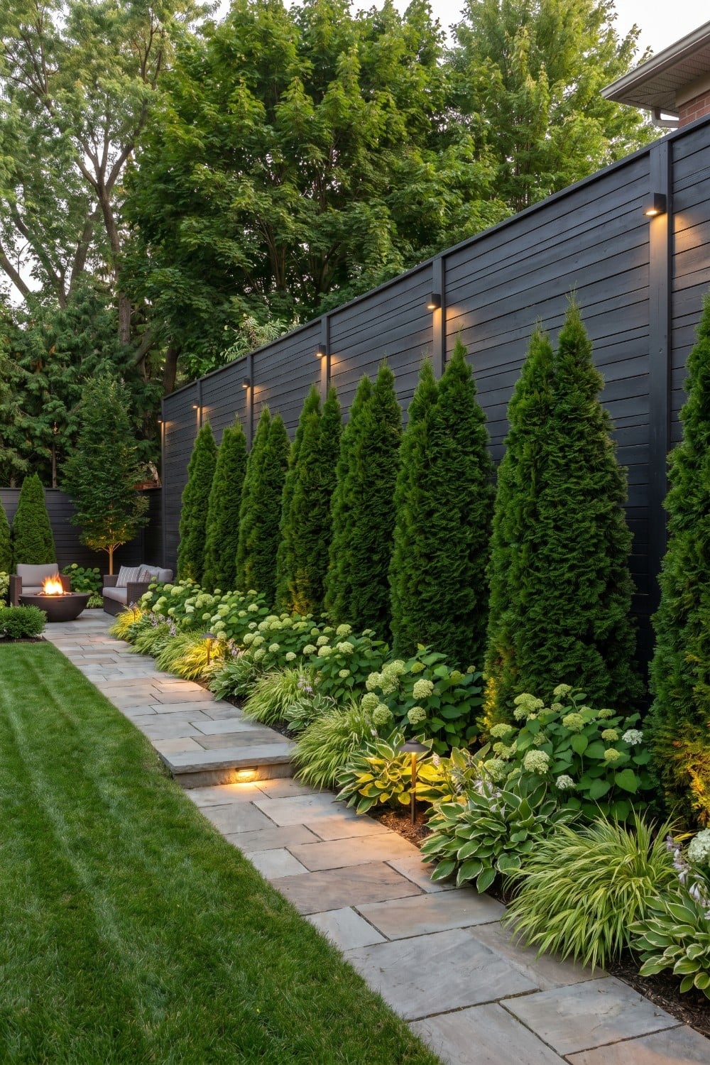 Black Tall Privacy Fence with Vibrant Evergreen Border